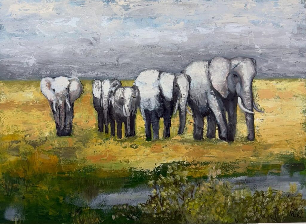 A herd of elephants walking through the desert brush.
