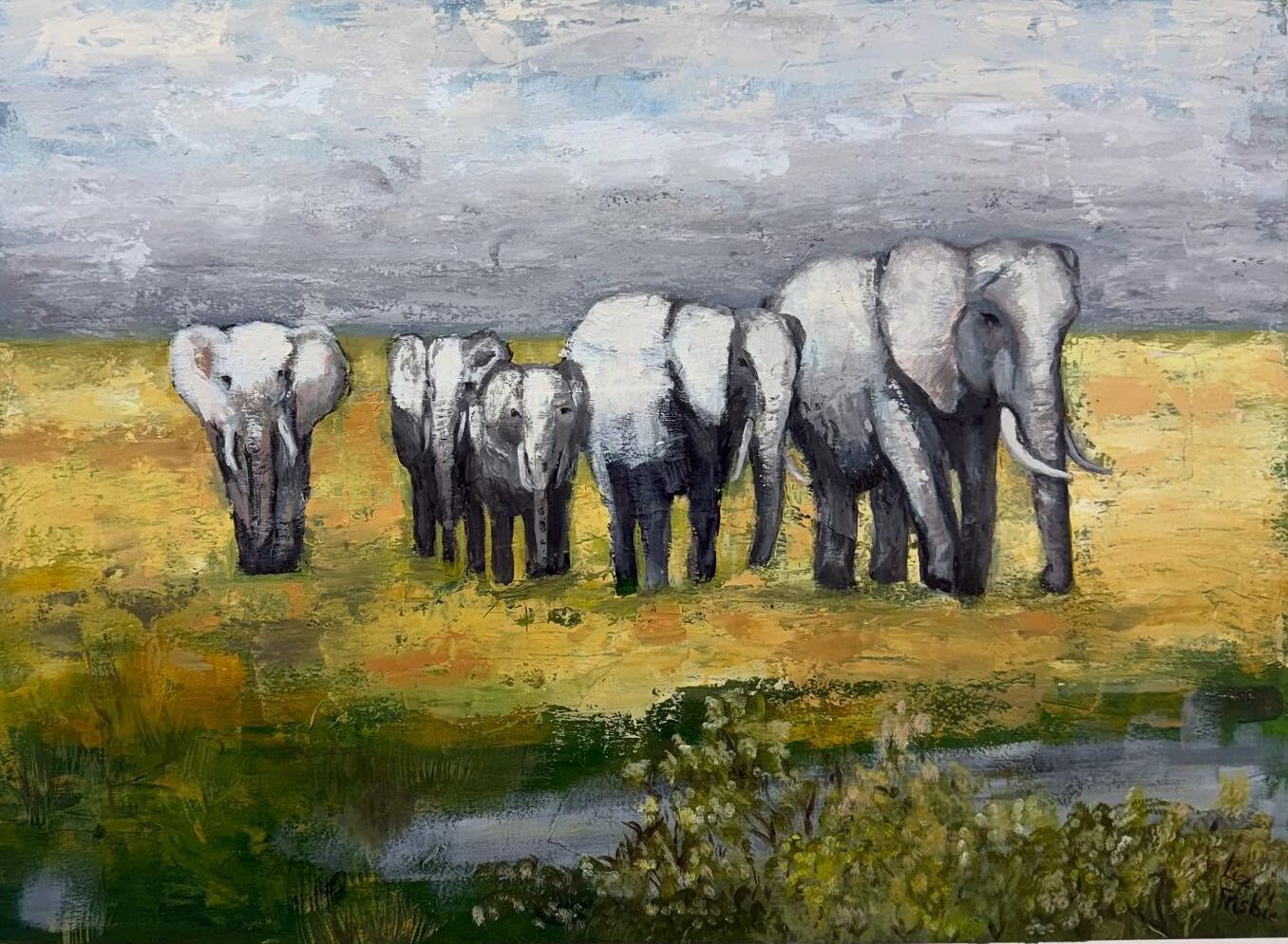 A herd of elephants walking through the desert brush.